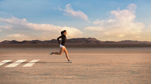 A woman running in the desert while wearing Lululemon clothing.