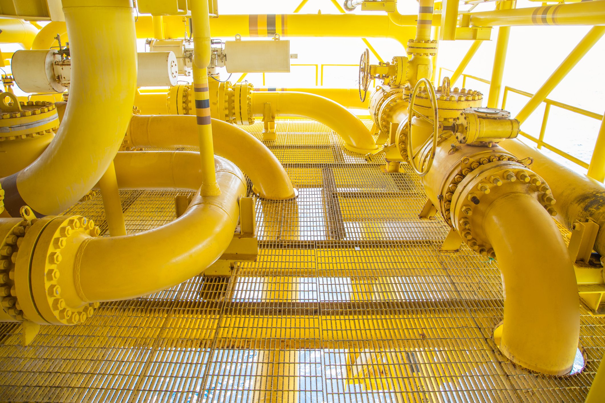 Yellow piping snaking through an industrial site.