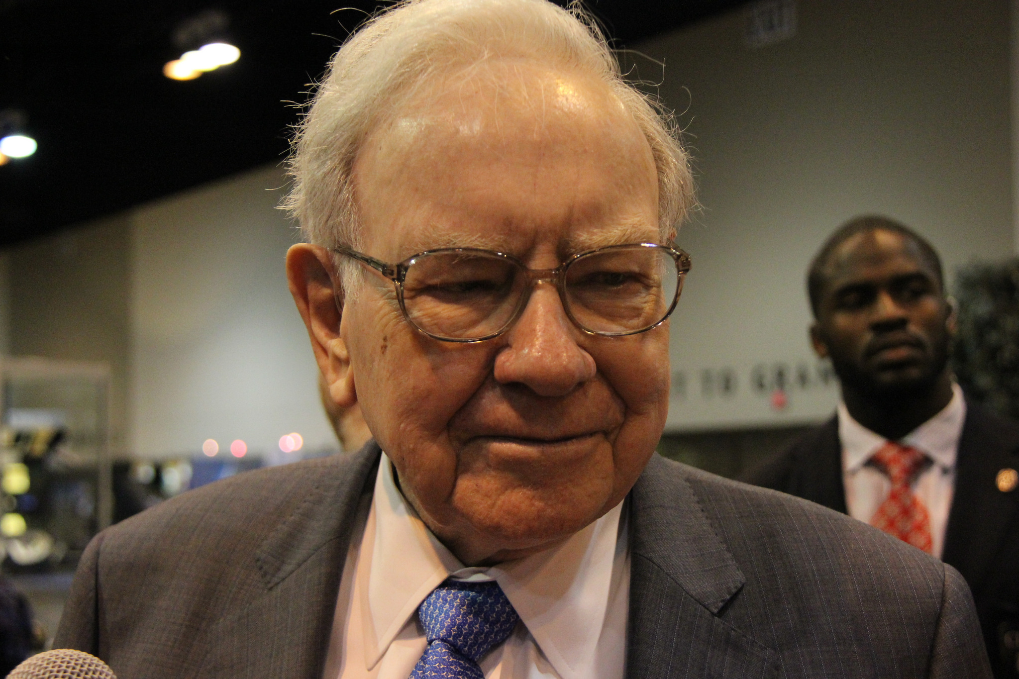 Warren Buffett, with a person in the background.