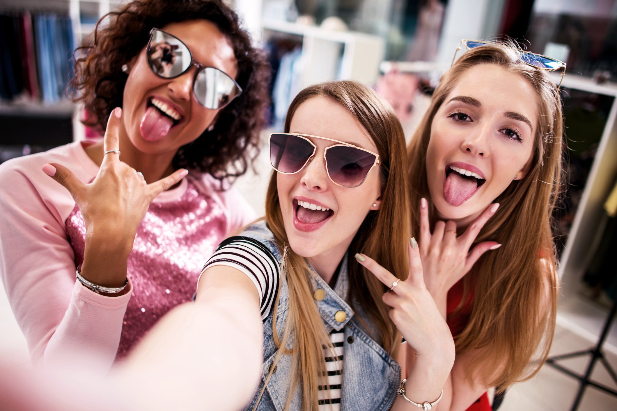 Three young girls taking a selfie while shopping.