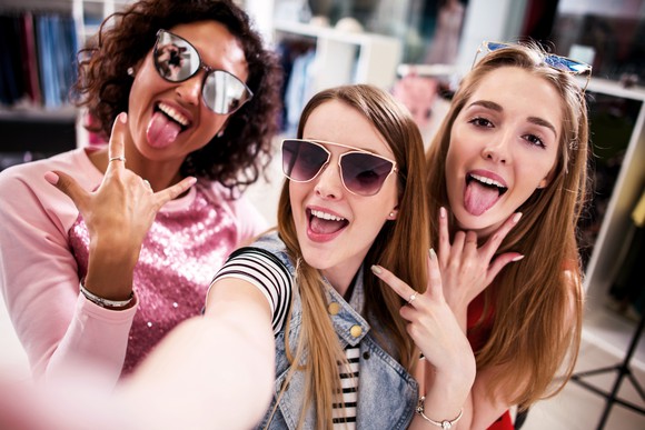 Three young girls taking a selfie while shopping.