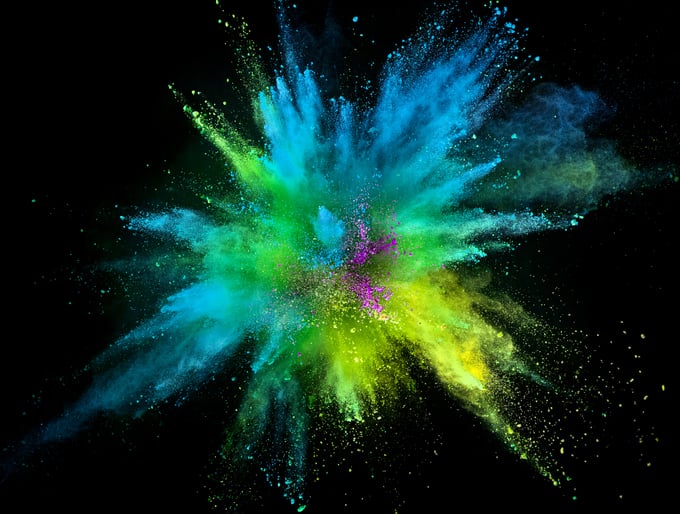 A explosion of blue, yellow, and green colors on a black background.