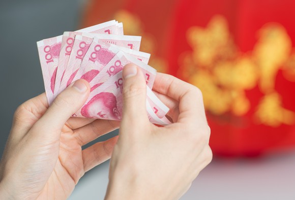 Hands counting Chinese yuan notes