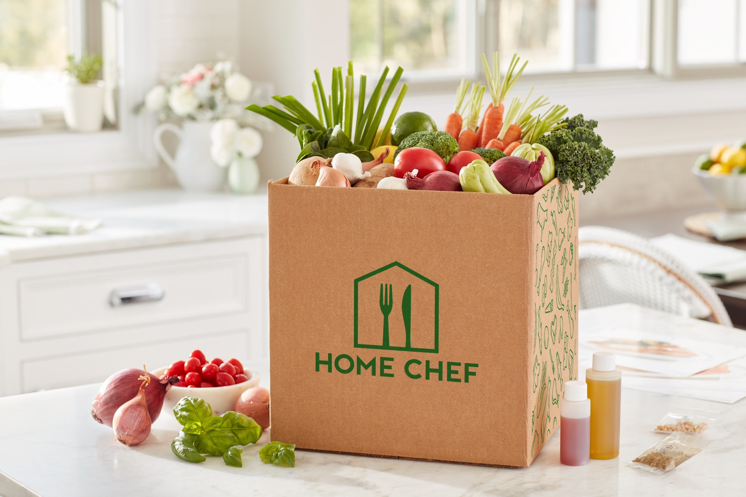 Vegetables inside a Home Chef box on a kitchen table