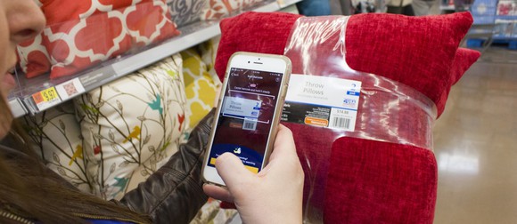 A person uses an app in a Walmart store.