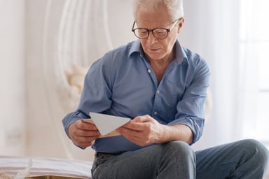 senior man holding envelope_GettyImages-669842410