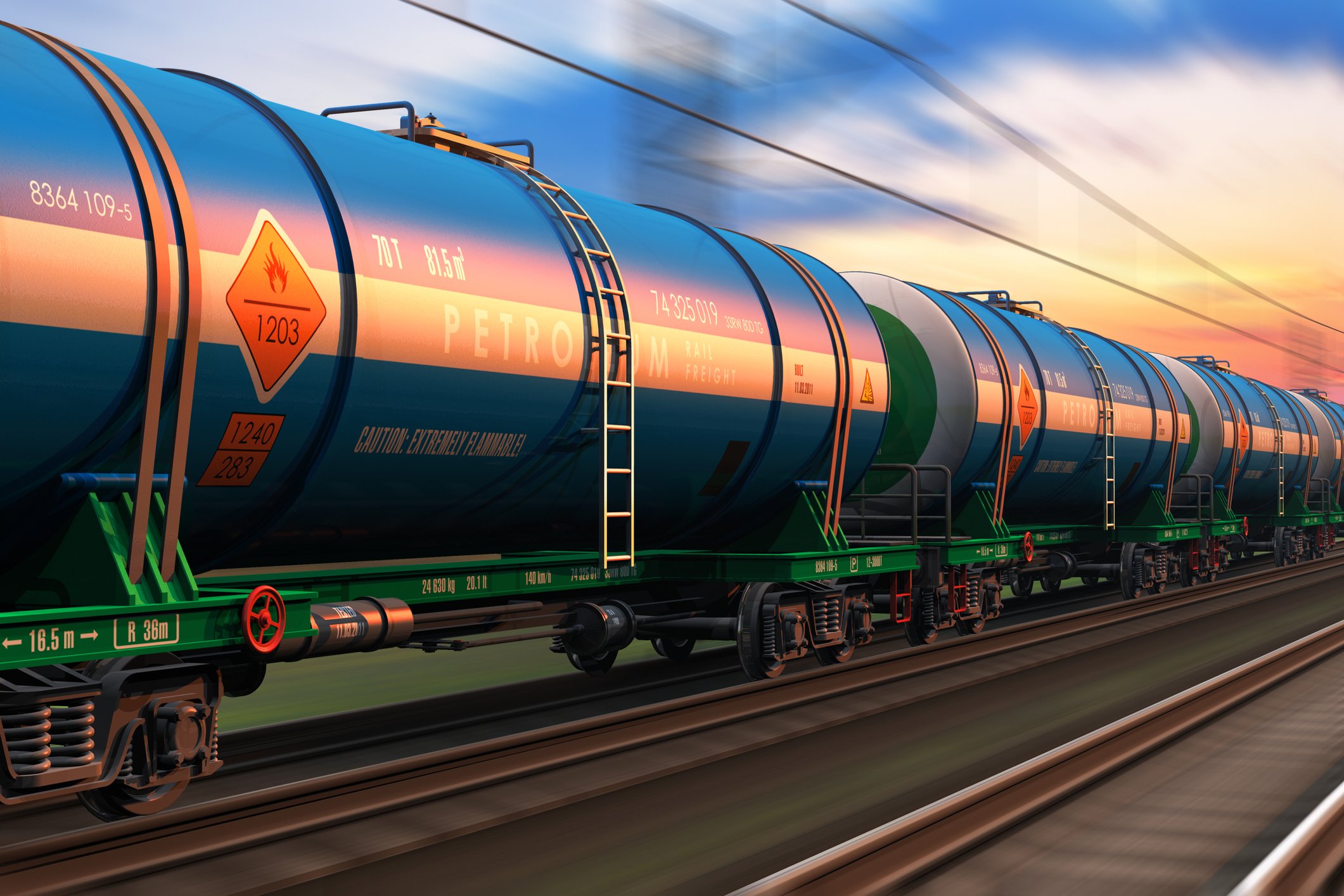A freight train with tanker cars at sunset.