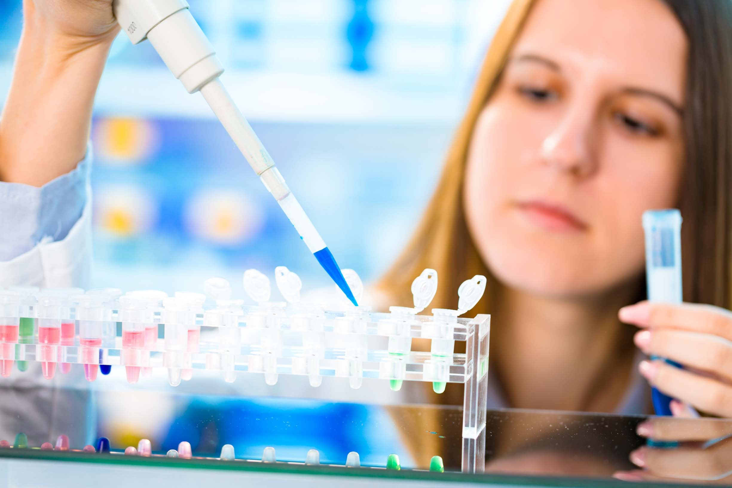 Woman using pipette to fill small vials