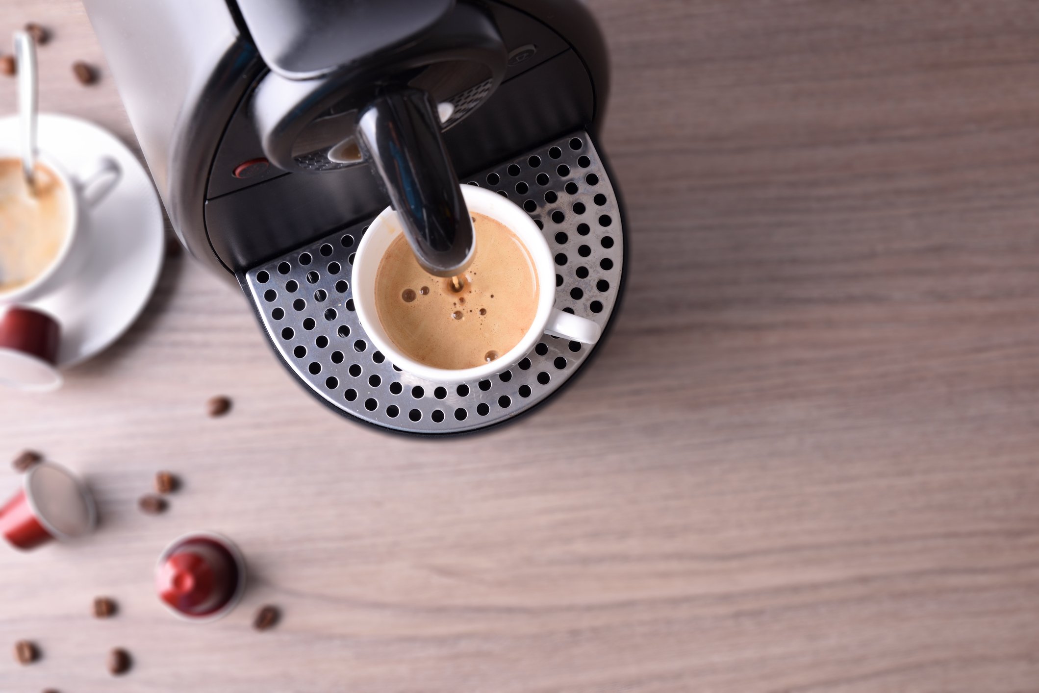 A coffee pod machine brewing a single serving of coffee.
