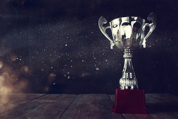 A trophy on top of a wooden table.