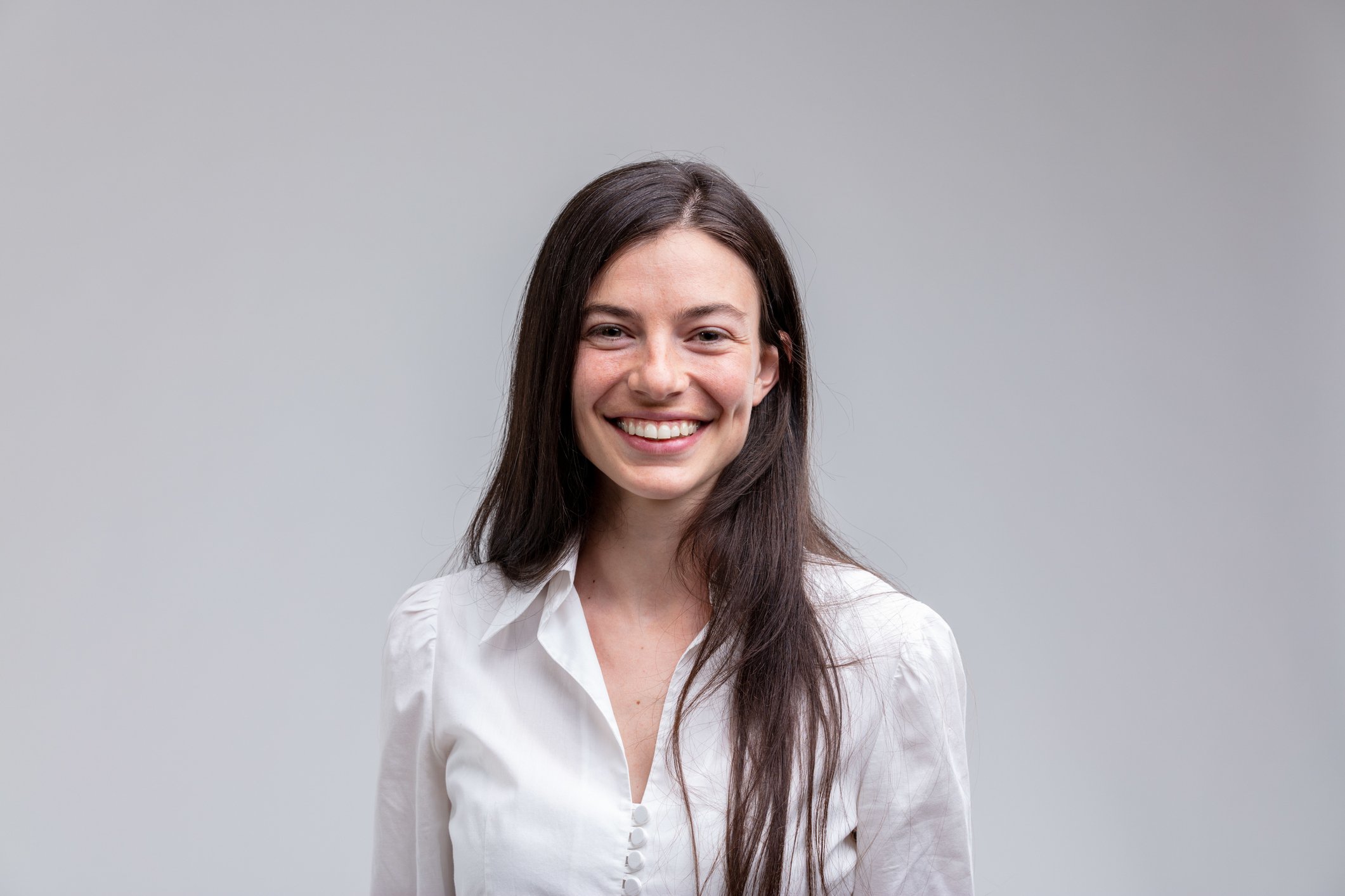 Smiling young woman in white shirt with long hair 