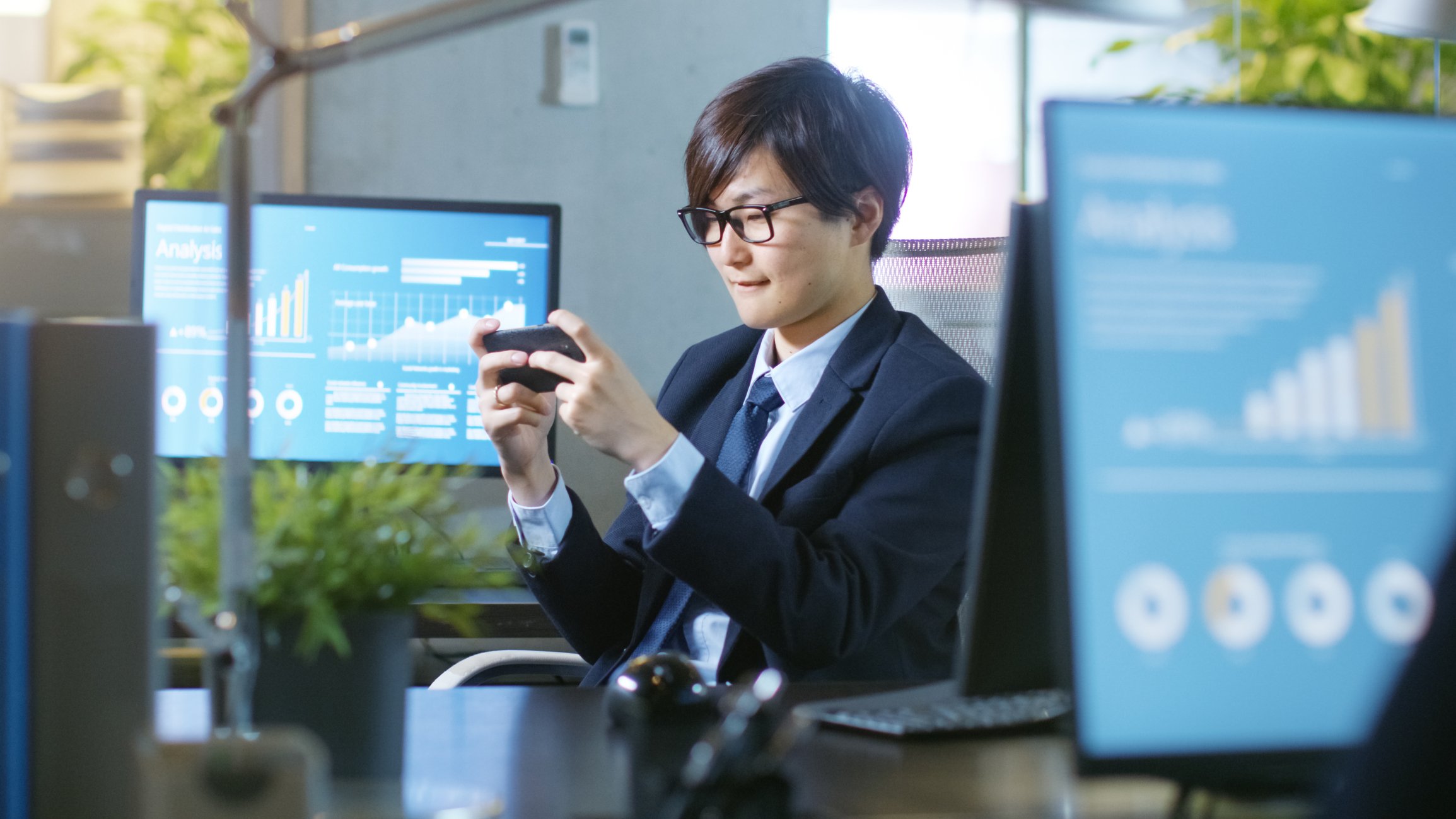 A businessman plays a mobile game at work.