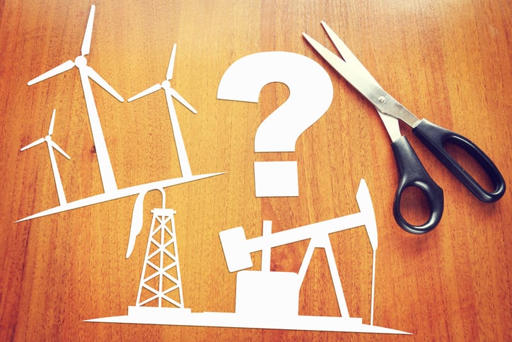 Paper cutouts of wind turbines, an old oil well, and a question mark.