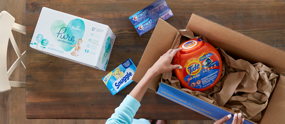 A woman hands pulling items out of a shipping box with the Walmart logo printed on the side.