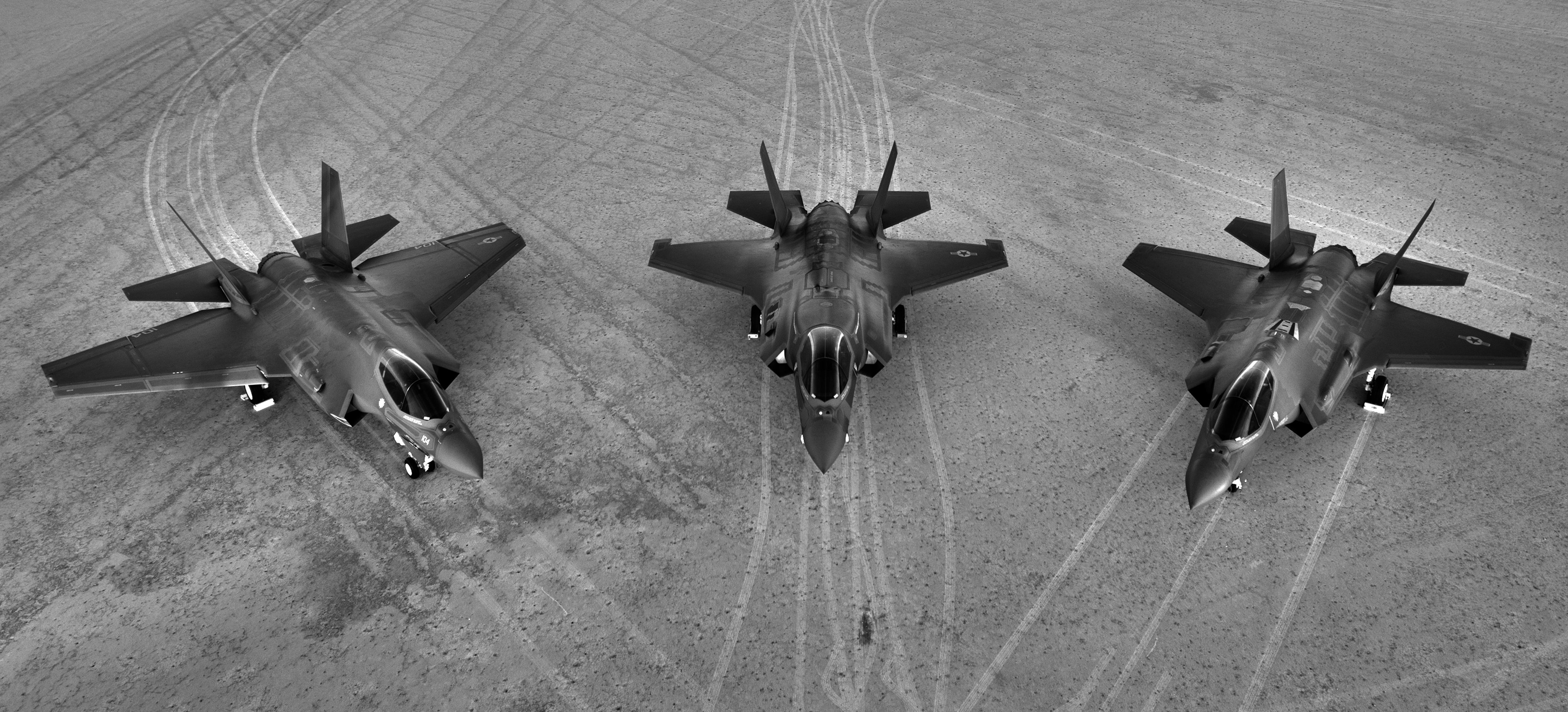 Three F-35 Joint Strike Fighters parked on a runway
