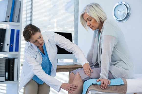 A doctor examining a patient's knee.