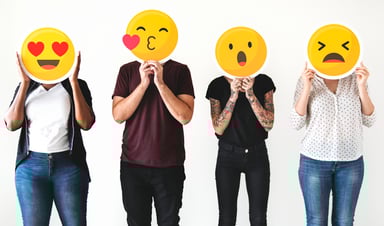 People holding common emojis over their faces