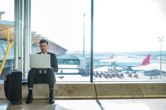 A business traveler uses a laptop at the airport.