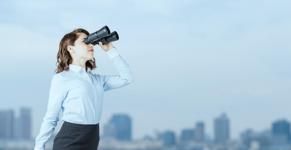 A woman looking through binoculars.
