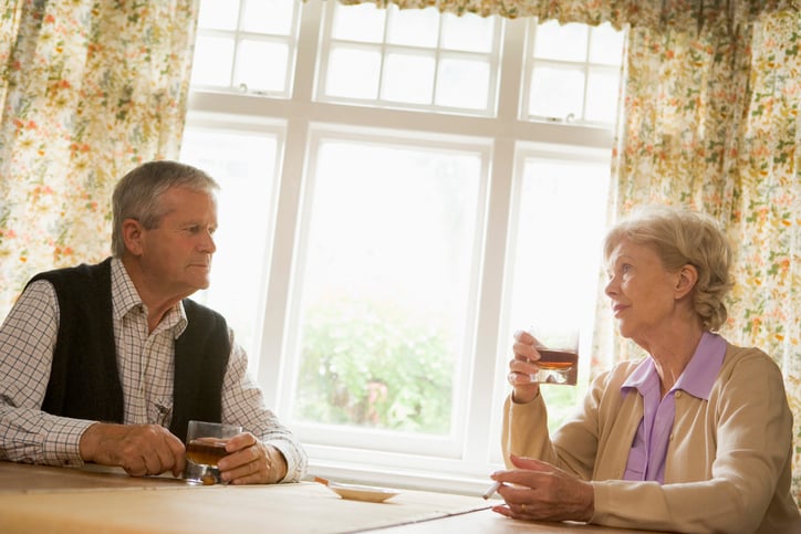 Senior couple at table with serious expressions