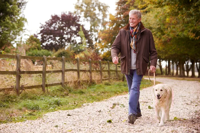 Smiling older man walking dog