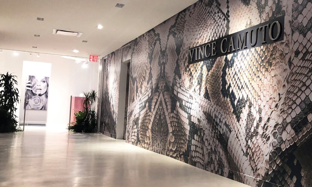 Mosaic-designed wall with Vince Camuto sign on it.