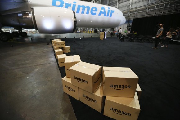 Amazon boxes lined up in front of a Prime Air cargo plane.