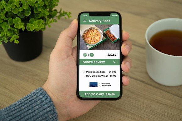 A customer orders food delivery on his mobile phone at home.