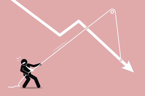 A stick figure businessman trying to pull a falling chart higher with a pulley system.