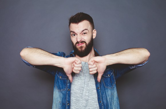 An angry man gives two thumbs down.