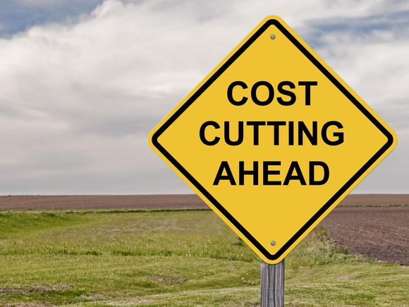 A yellow sign that reads cost cutting ahead.