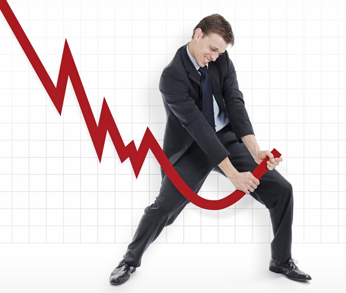 Businessman pulling red line that was trending downward back up