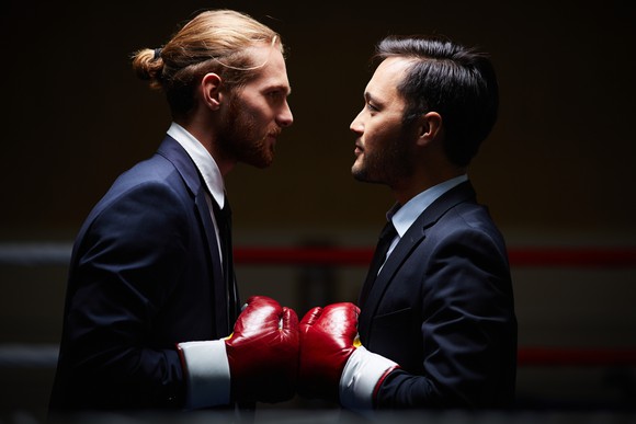 Two businessmen in boxing gloves.