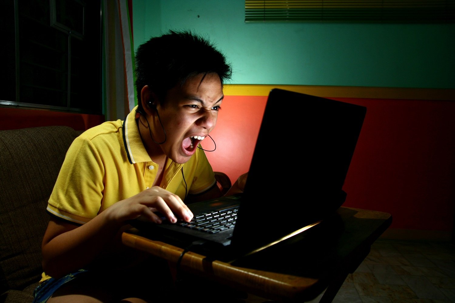 Young Asian man using a laptop computer. 