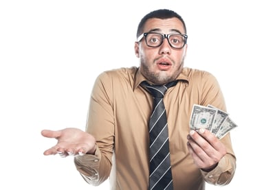 sheepish man holding money_GettyImages-497828228