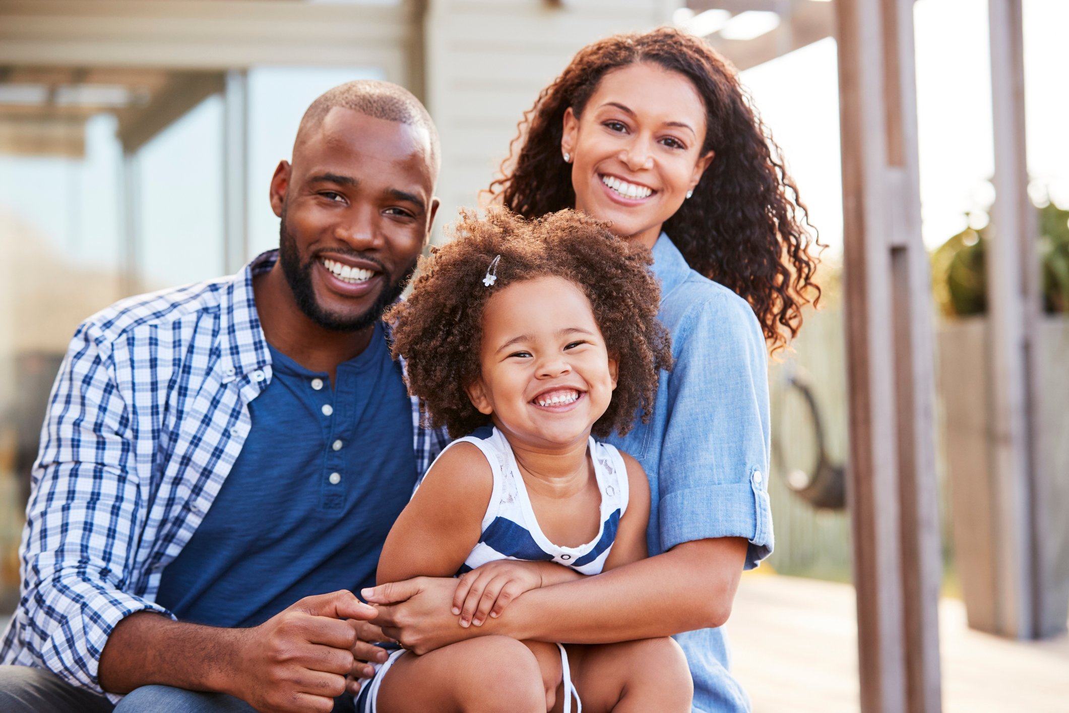 Man, woman, and young girl smiling.