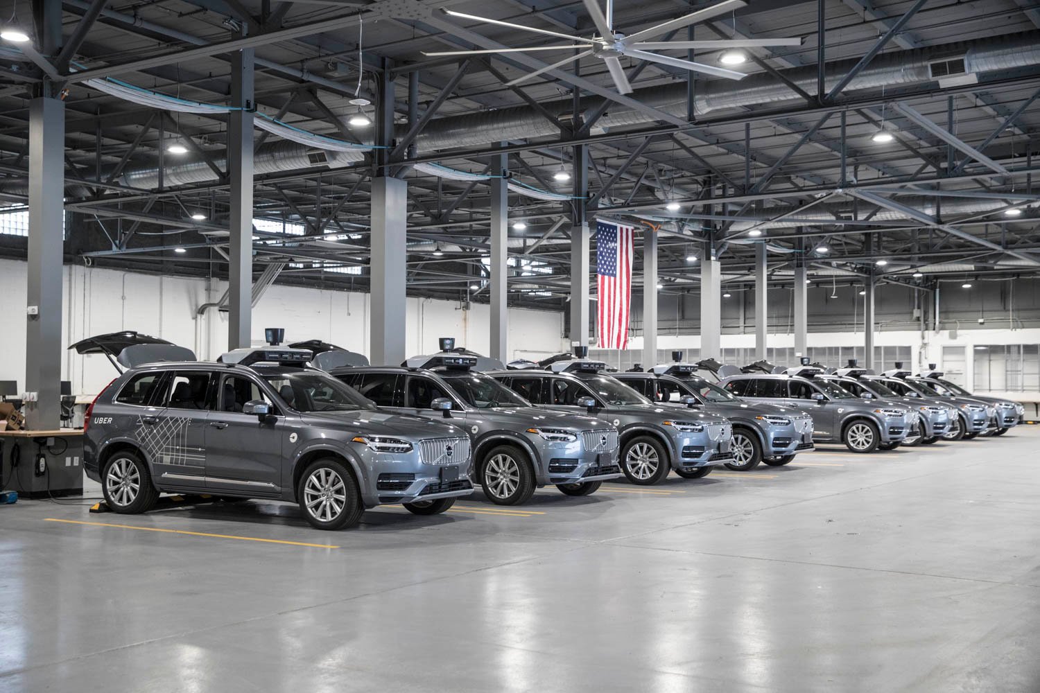 A row of Volvo SUVs in a warehouse.