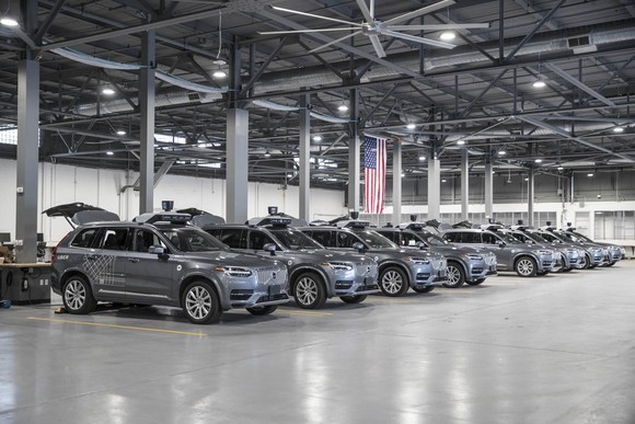 A row of Volvo SUVs in a warehouse.