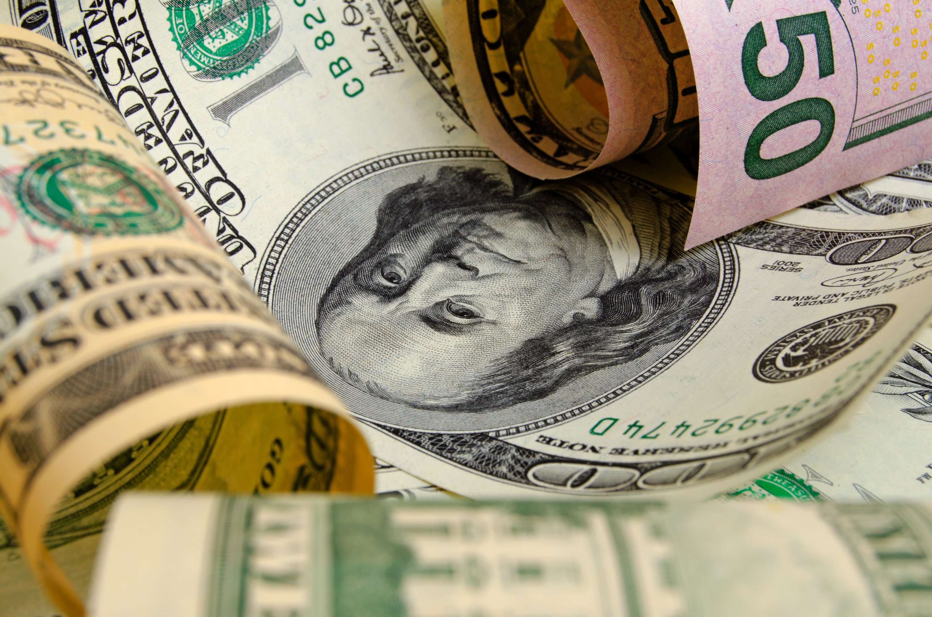 U.S. currency rolled up together.