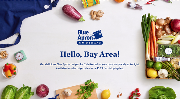 Blue apron and food items on a white table, with logo and text.