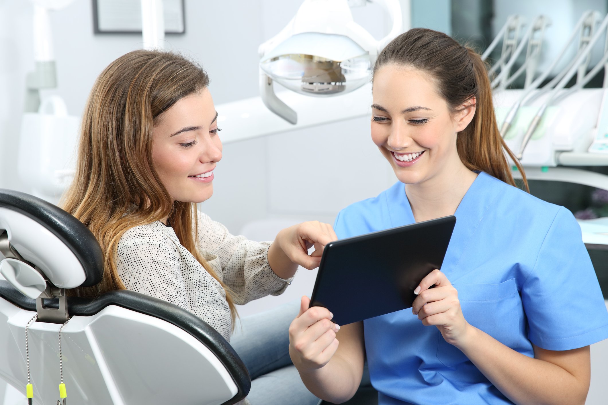 Dentist showing tablet computer to her patient
