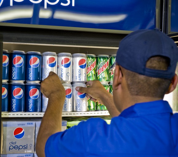A Pepsi worker stocking a cooler.