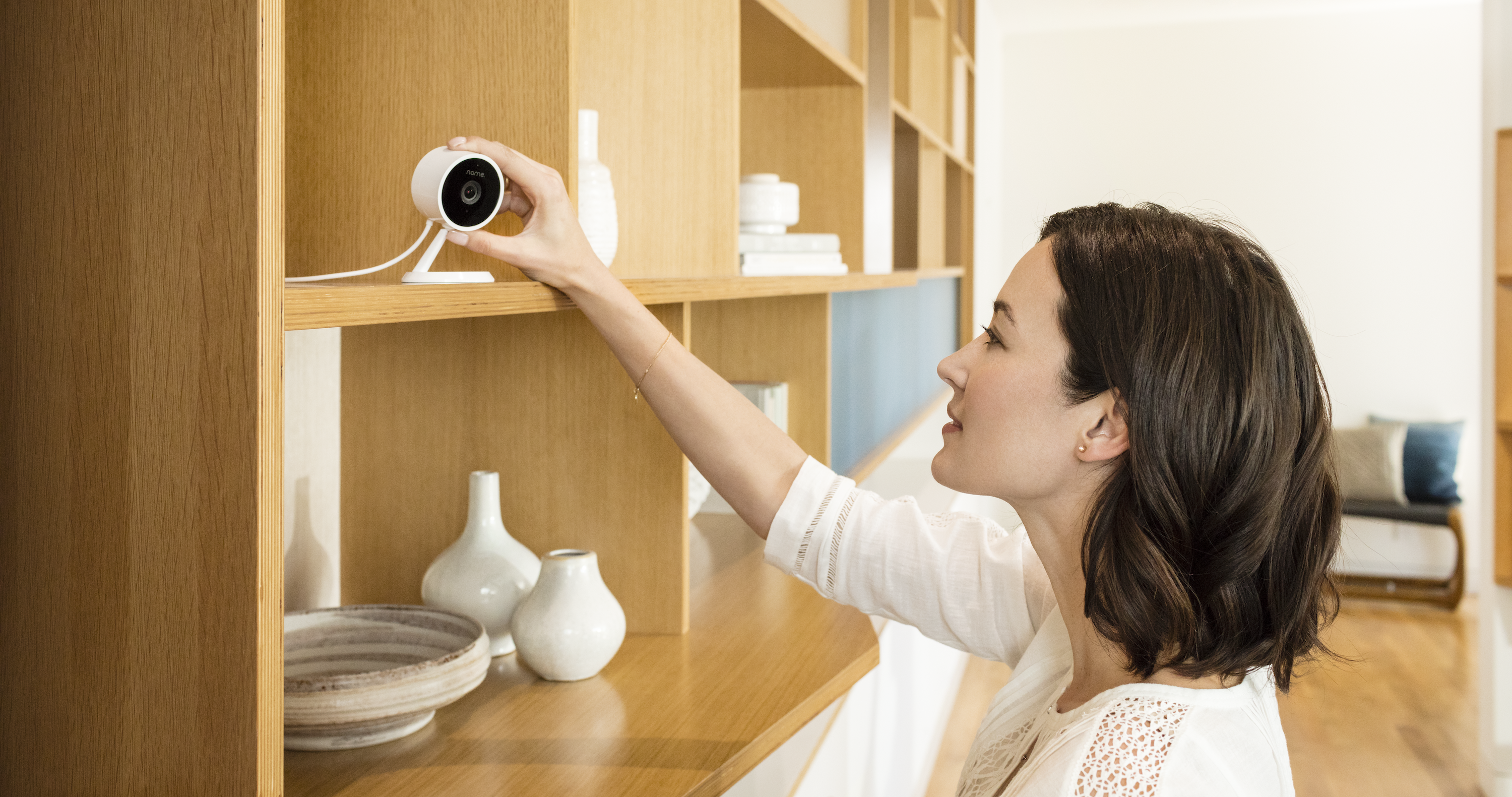 Woman setting up Amazon Cloud Cam on a shelving unit