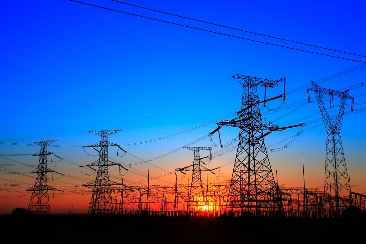 Several power lines and transformers on a clear day near sunset or sunrise.