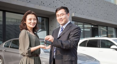 Asian auto salesman customer keys source Getty