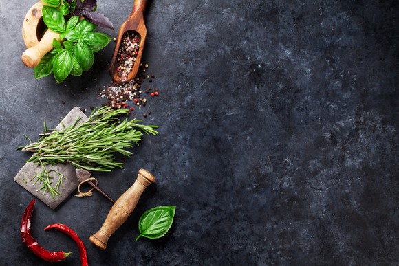 Assorted herbs and spices on a marble table.
