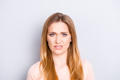 Closeup of woman cringing_GettyImages-961388254