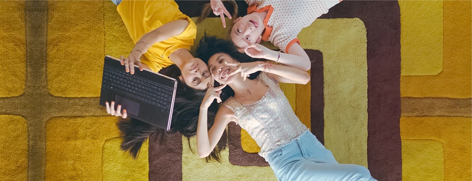 A family takes a picture with a convertible HP laptop.