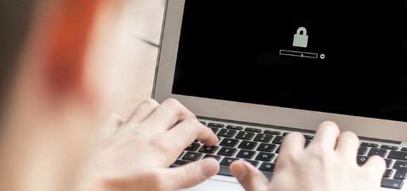 A person logging onto a laptop