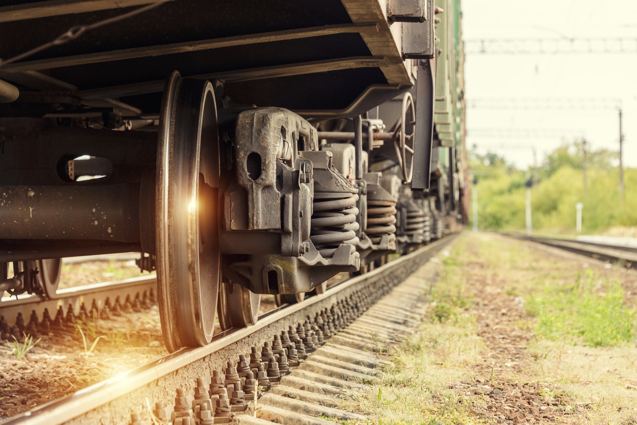 A ray of sunshine reflects off a freight train wheel.